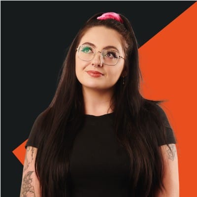 senior social media marketer, Rebecca Gilchrist headshot, standing looking up smiling, wearing a black top.