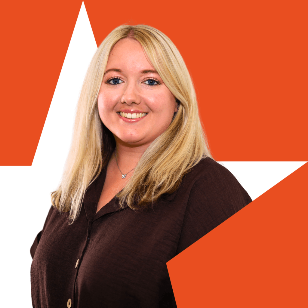 a headshot photo of our SEO account manager Charlotte, who is smiling and looking happy. Wearing a smart brown shirt